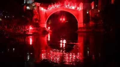 A diver holding torches jumps from the Old Bridge during a night show, part of the 456th annual high-diving competition in Mostar, Bosnia. AP
