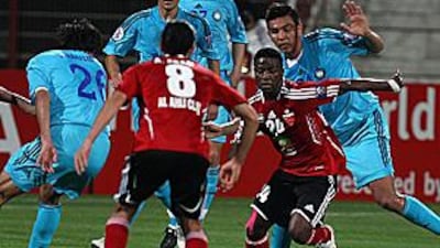 Ahli's Ismail al Hammadi, second right, is swamped by Pakhtakor players at the Al Rashid Stadium in Dubai on Tuesday night.