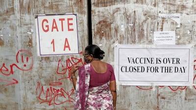 A woman, who came to receive a dose of a coronavirus disease vaccine, stands in front of a closed gate of a vaccination centre which was closed due to unavailability of the supply of COVID-19 vaccine, in Mumbai, India. Reuters