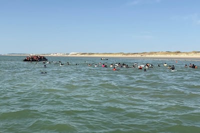Migrants making their way to the vessel from the shore. AFP