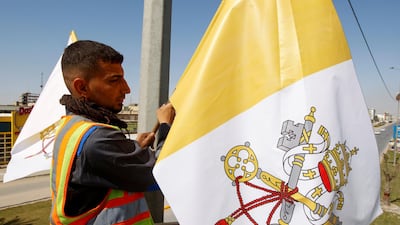 A worker hangs a Vatican flag at a utility pole ahead of Pope Francis's planned visit, to Najaf, Iraq. Reuters