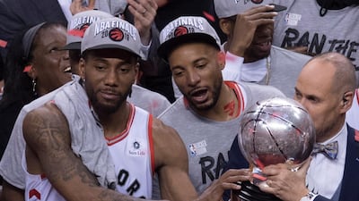 Toronto Raptors' Kawhi Leonard, left, hands teammate Norm Powell the trophy. AP Photo
