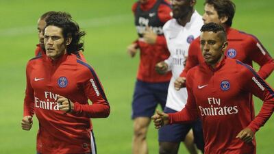 Paris Saint-Germain's (PSG) players Uruguyan forward Edinson Cavani (L) and Brazilian defender Marquinhos run during a training session at the team's training camp in the Qatari capital Doha, on December 29, 2015 on the eve of their friendly football match against Italian league leaders Inter Milan. AFP PHOTO / KARIM JAAFAR