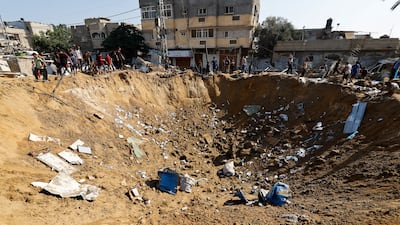 Palestinians gather at the site of an Israeli strike on a medicine warehouse in Deir Al Balah, in central Gaza. Reuters