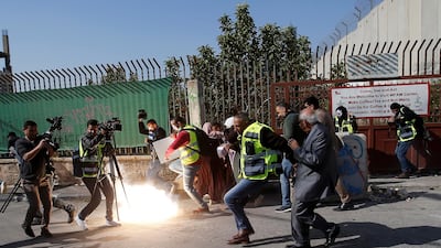 Palestinian journalists react to a stun grenade fired by Israeli forces during a protest in Bethlehem to show solidarity with their colleague Muath Amarneh. REUTERS