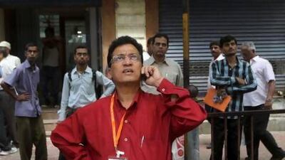 Indians watch a display screen on the facade of Bombay Stock Exchange building in Mumbai. The stock market has dropped 10 per cent in the past three months and the rupee has lost a sixth of its value against the dollar since the start of the year.