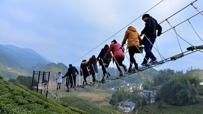 Tourists walk above a tea plantation in Enshi, Hubei province, on December 27, 2015. Reuters / Stringer