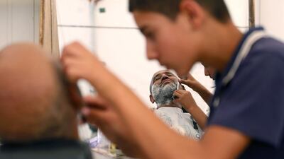 A Syrian refugee barber trainee shaves a man at one of the vocational training centres of the The Norwegian Refugee Council (NRC) at Al Zaatari refugee camp in the Jordanian city of Mafraq, near the border with Syria. Muhammad Hamed / Reuters
