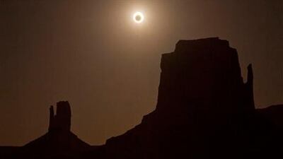 The new moon crosses in front of the sun creating an annular eclipse over West Mitten, left, and East Mitten buttes, Sunday, May 20, 2012, in Monument Valley, Ariz. (AP Photo/Julie Jacobson)