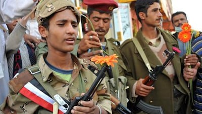 Yemeni soldiers hold flowers they received from anti-government protesters demanding the departure of President Ali Abdullah Saleh, during protest in the capital. Sana'a, yesterday.