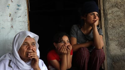 Displaced Iraqi Yazidi women sit outside a tent at a camp in Khanke, a few kilometres from the Turkish border in Iraq's Dohuk province, on June 24, 2019. AFP