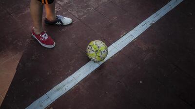 A boy wearing different shoes plays football in a neighbourhood of Managua, on January 13, 2016. Football is gaining enthusiasts in Nicaragua where baseball has been historically dominant but is now giving way to the new sport, analysts said. Inti Ocon / AFP