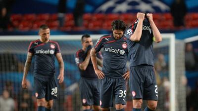 Olympiakos players Giannis Maniatis, right, Alejandro Dominguez, centre, and Jose Holebas, left, react after losing to Manchester United on Wednesday. Peter Powell / EPA / March 19, 2014