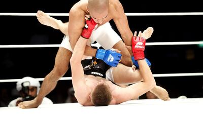 Emirati Ahmad Al Darmaki, top, put on a valiant effort against Artiyom Gorodynets in their featherweight fight at the Abu Dhabi Warriors Fighting Championship III held at Zayed Sports City , IPIC Arena on October 3, 2015. Vidhyaa for The National