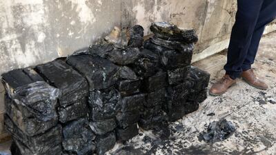Bags of banknotes retrieved from the underground coffers of a central bank branch in the northern Iraqi city of Mosul, once a stronghold of the Islamic State(IS) group, are piled up on the floor, on October 20, 2021. - In the imposing building with gaping holes and a blackened ceiling, workers removed sacks containing packs of banknotes rolled up in black plastic bags from a hole in the floor. When IS militants took Mosul in the summer of 2014, they seized several hundred million dollars as well as gold bars from the Mosul branch of Iraq's central bank. (Photo by Zaid AL-OBEIDI / AFP)