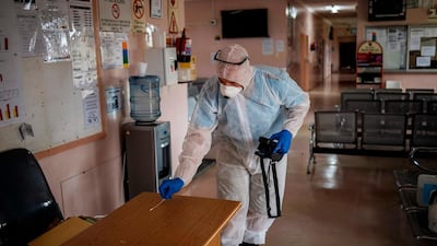 A worker performs a swab test on a desk at the Duduza Clinic that has been shut down after a nurse tested positive for the COVID-19 coronavirus in Ekurhuleni, South Africa. AFP