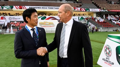 Japan's coach Hajime Moriyasu, left, shakes hands with Oman's coach Pim Verbeek. AFP