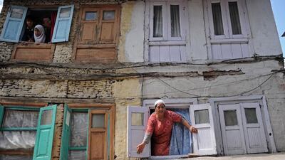 Women react as they stand at the windows of a house watching Kashmiri Muslims carry the body of 20-year-old Riyaz Ahmed Shah during his funeral in downtown Srinagar. Tauseef Mustafa / AFP