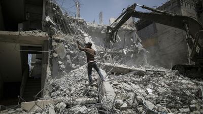 Palestinian men work on the remains of a building destroyed during Israel's 2014 war on Gaza on April 30, 2016, in Gaza City. Mahmud Hams/AFP Photo