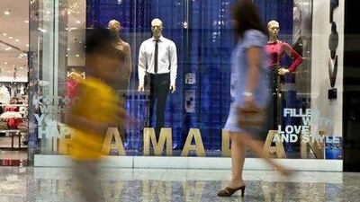 Shoppers walk by festively staged shop windows during Ramadan. Silvia Razgova / The National