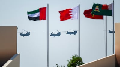 Chinook transport helicopters fly past the Emirati and Bahraini flags