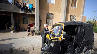 Syrian refugee Ahmad al-Khatib cleans his auto rickshaw as his wife Ilham Mohammad watches, outside their home in Cairo, Egypt. Reuters