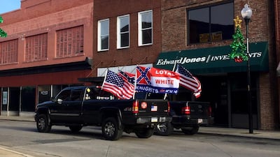 A pickup bearing the Confederate flag and emblems of the Ku Klux Klan drives up Main Street in the small North Carolina town of Roxboro. Natalie Allison Janicello for The National