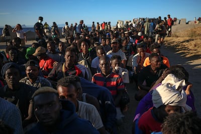 Migrants wait in line to receive food from the Red Cross in Ceuta. Reuters