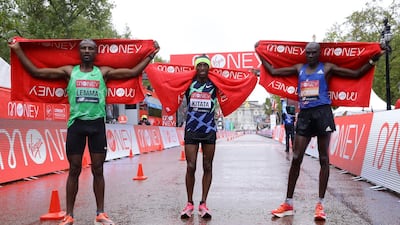 Ethiopia's Shura Kitata, centre, celebrates winning the men's elite race alongside second placed Kenya's Vincent Kipchumba, right, and third placed Ethiopia's Sisay Lemma. PA