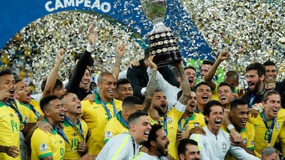 Brazil's Dani Alves lifts up the trophy as Brazil celebrate their success. AP Photo