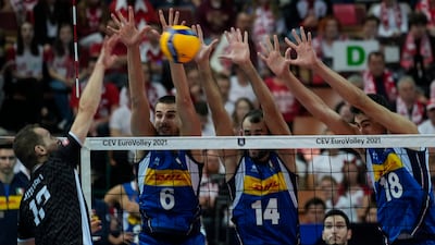 Slovenia's Tine Urnaut, left, spikes the ball past, left to right, Simone Giannelli, Gianluca Galassi and Alessandro Michieletto of Italy during the European Championship volleyball final at the Spodek Arena in Katowice, Poland, on Sunday, September 19. AP