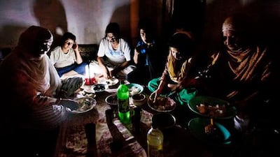 A Kashmiri Muslim family eats dinner by torchlight after breaking their Ramadan fast. Millions were left without power during India's worst blackout in history.