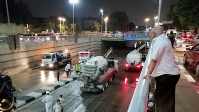 A man watches rescue vehicles withdrawing water by suction from the al-Oroba tunnel in the Heliopolis district after rain led to traffic jam in the Egyptian capital Cairo. AFP