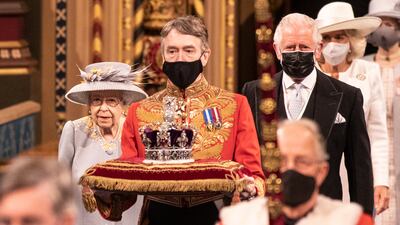 Queen Elizabeth, escorted by Prince Charles, follows the imperial state crown along the royal gallery during the state opening of Parliament at the House of Lords in May.