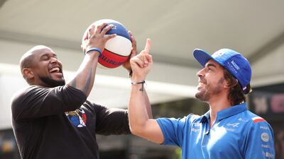 Alpine driver Fernando Alonso with Harlem Globetrotters' Scooter ahead of the Australian Grand Prix. Reuters