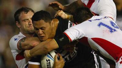 New Zealand's David Kidwell is brought down by the England defence.