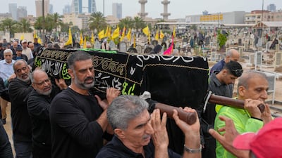 People carry a coffin of a person killed during a drone attack on a high-rise apartment building in Bahrain's capital, Manama, to its grave during a burial on Tuesday. AFP