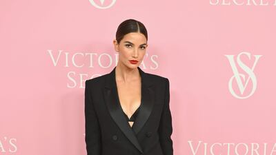 Lily Aldridge sports stovepipe trousers, a double-breasted coat and the barest hint of a bralette underneath. AFP