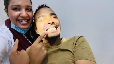 Mr Omer shows off his teeth after having dental work carried out by his wife, who is a dentist.
