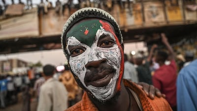 A Sudanese protestor poses with a Sudan national flag painted on his face during a protest outside the army complex in the capital Khartoum on April 20, 2019. The new government faces a difficult task to revive the economy. AFP