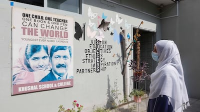 Marjan looks at a poster of Malala and her father, Ziauddin Yousafzai, on a wall at Khushal School and College.