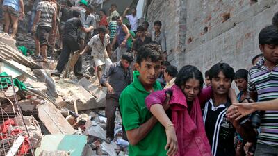 Rescuers assist an injured woman from the rubble. AP Photo/ A.M. Ahad