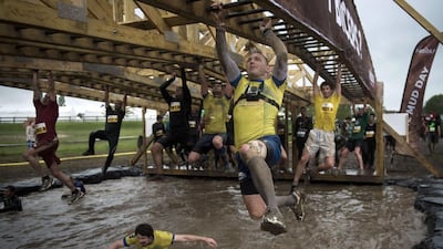 Runners take part in 'The Mud Day challenge', a 13-kilometre obstacles course, on in Beynes near Paris, on Saturday. Martin Bureau / AFP