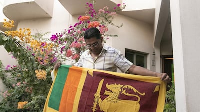 Sri Lankan Ajantha Premarathne, proudly holding his nation's flag, believes a change in government can help unite the country. Reem Mohammed/The National
