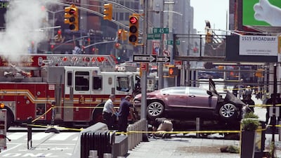 Investigators examine a car that ploughed through crowds of pedestrians before stopping on the corner of Broadway and 45th Street in New York’s Times Square on May 18, 2017. Seth Wenig / AP Photo