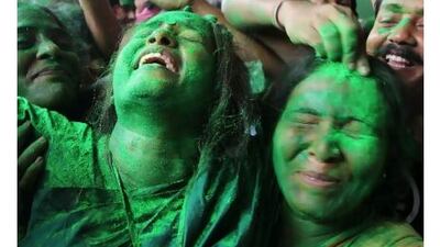 Trinamool Congress Party supporters, covered in green paint to show their party allegiance, celebrate outside the residence of the leader Mamata Banerjee in Kolkata yesterday, after she crushed the ruling Communist Party of India (Marxist) at elections, taking 200 seats to the latter's 70. Jayanta Shaw / AFP