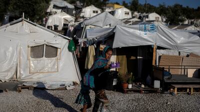 A migrant from Afghanistan and her daughter make their way at a makeshift camp for refugees and migrants next to the Moria camp on the island of Lesbos, Greece. Reuters
