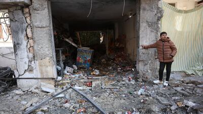 A boy stands next to a destroyed building after an air strike in Idlib, northern Syria. EPA