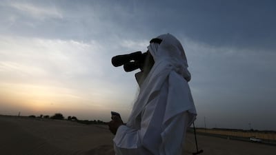 A man looks for the new crescent moon to indicate the start of a new Islamic month. Pawan Singh / The National