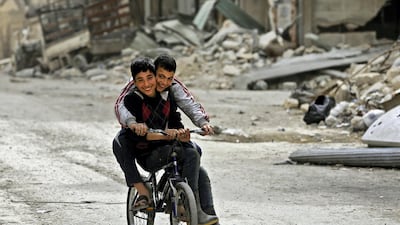 Syrian children play in a neighbourhood in Aleppo previously held by rebel fighters. AFP